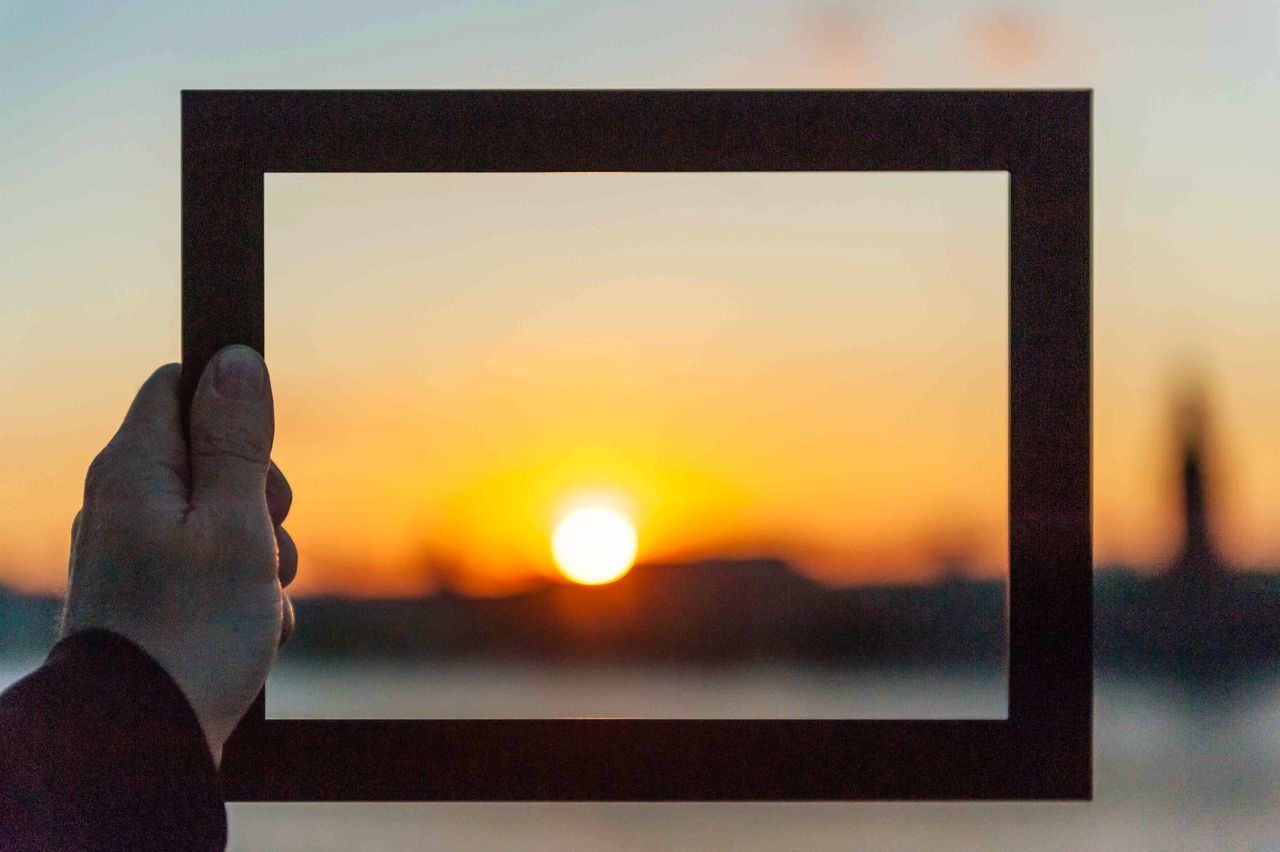 sunset, sun, orange color, sky, silhouette, part of, indoors, sunlight, scenics, beauty in nature, window, cropped, nature, glass - material, person, tranquility, tranquil scene, idyllic