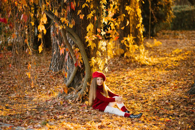 Cute baby girl with long hair in autumn in the park smiling and enjoying a sunny day