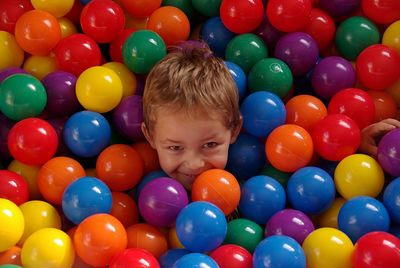 Portrait of cute boy by multi colored balls