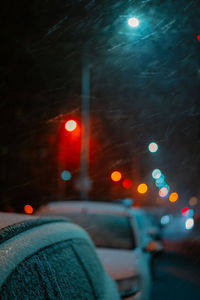 Snowing on cars at night during winter