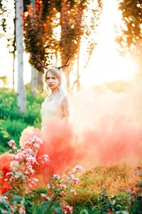 Portrait of bride standing in pink smoke