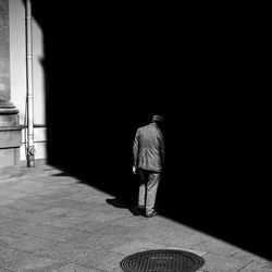 Rear view of man walking in corridor