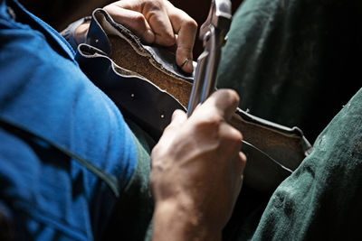 Cropped image of man using repairing shoes
