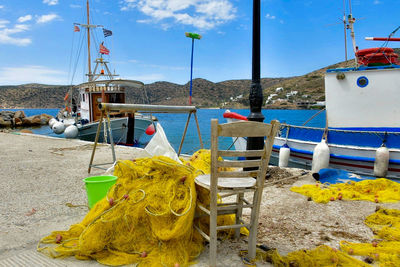 Fishing boats moored at harbor against sky