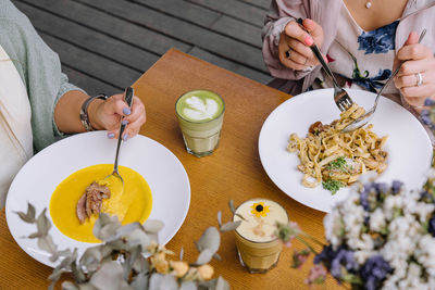 Midsection of woman having food on table