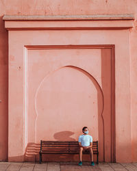 Rear view of woman standing against building