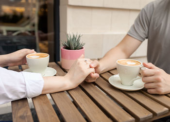 Midsection of woman using mobile phone on table