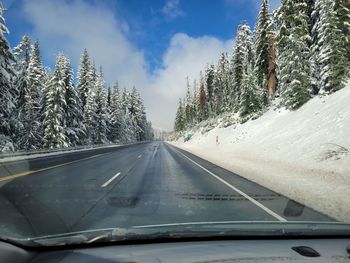 Road amidst trees against sky