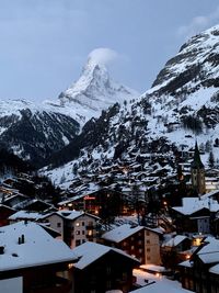 Houses in town against sky during winter