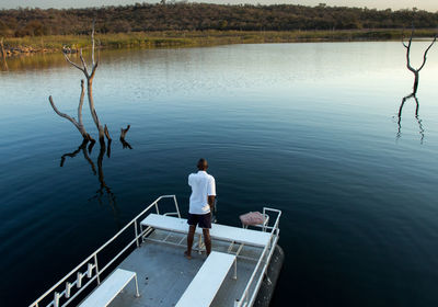 High angle view of man standing on boat deck in lake kariba