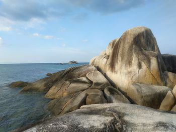 Rock formation in sea against sky