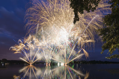 Firework display over river at night