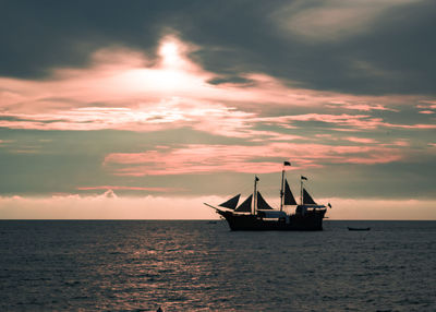 Boat sailing in sea at sunset