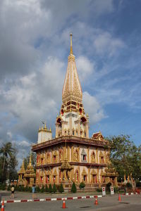 Tourists at grand palace against cloudy sky