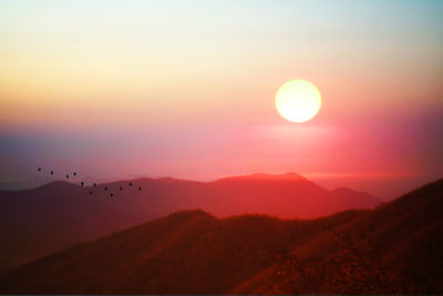 Scenic view of silhouette mountains against sky during sunset