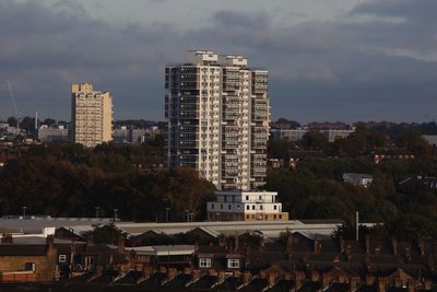 Buildings in city against cloudy sky