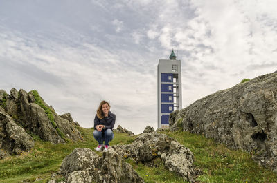 Woman standing on cliff against sky