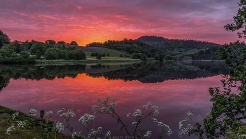 Scenic view of calm lake at sunset
