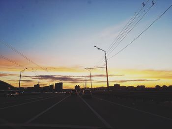 Silhouette railroad tracks against sky during sunset
