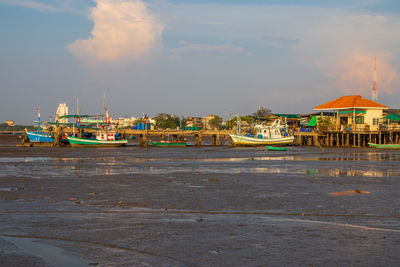 Boat moored on beach against sky