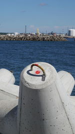 Close-up of metal by sea against sky