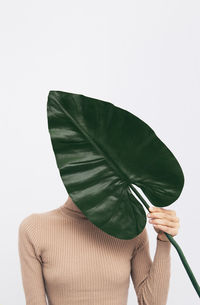 Close-up of person holding umbrella against white background