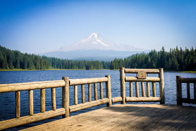 Pier over lake by mountain against sky