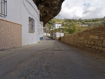 Empty road amidst buildings in city