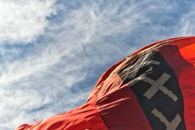 Low angle view of flag against cloudy sky