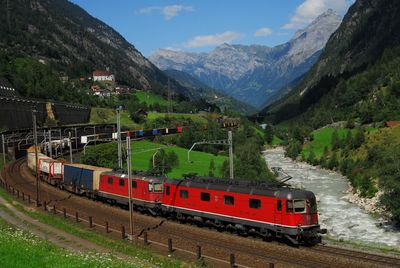 Train on railroad track by mountains against sky