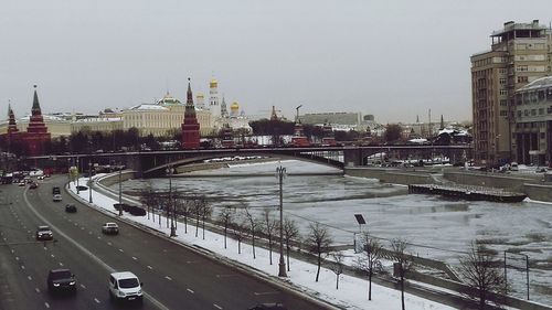 Bridge over river in city against sky