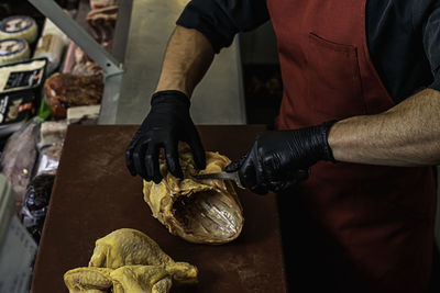 Professional butcher cutting chicken in the cutting board