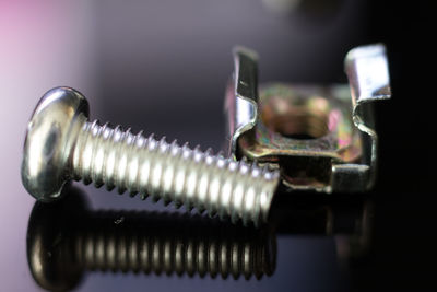 High angle view of metallic screw and hinge on table