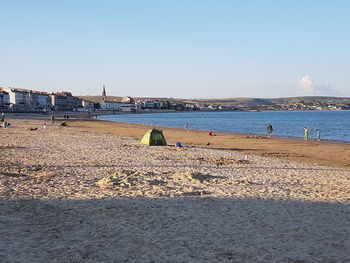 Scenic view of beach against clear blue sky