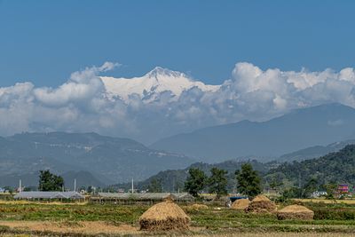 Scenic view of field and mountains against sky