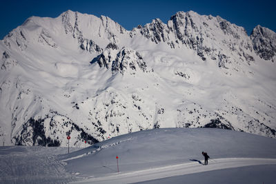 People skiing on snowcapped mountain against sky