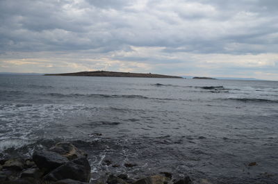 Scenic view of sea against cloudy sky