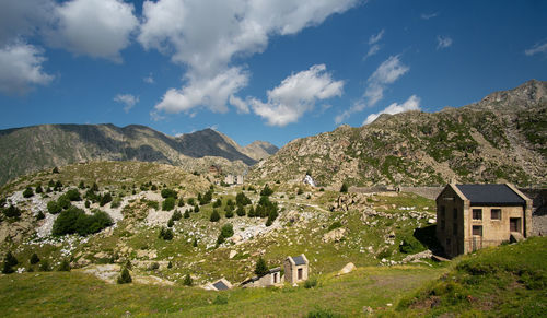 Scenic view of houses by mountains against sky