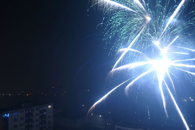 Low angle view of fireworks against sky at night