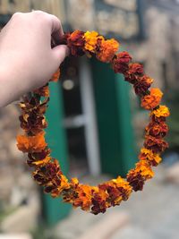 Close-up of hand holding flower garland