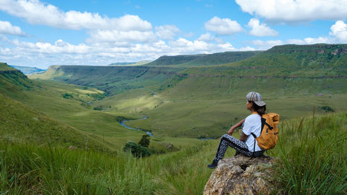 Rear view of man sitting on mountain