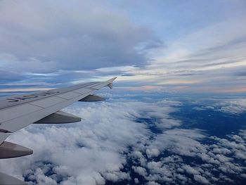 Cropped image of airplane flying over cloudscape