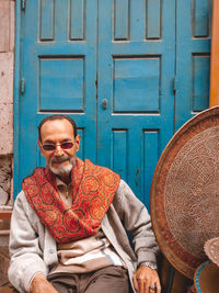 Portrait of man sitting on door