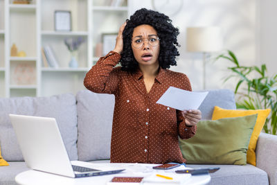 Portrait of young woman using laptop at home