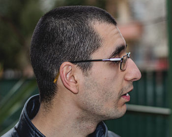 Portrait of young man looking away outdoors