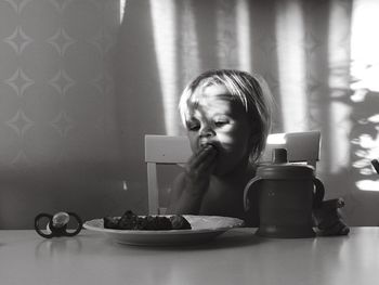 Toddler having food while sitting at table