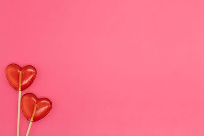 Close-up of heart shape over pink background