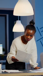 Woman sitting at illuminated table