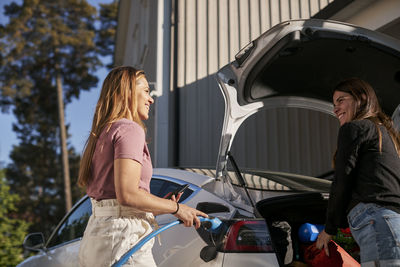 Women talking in front of car