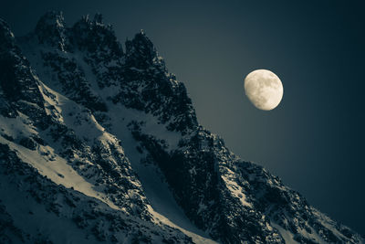 Low angle view of snowcapped mountain against sky at night